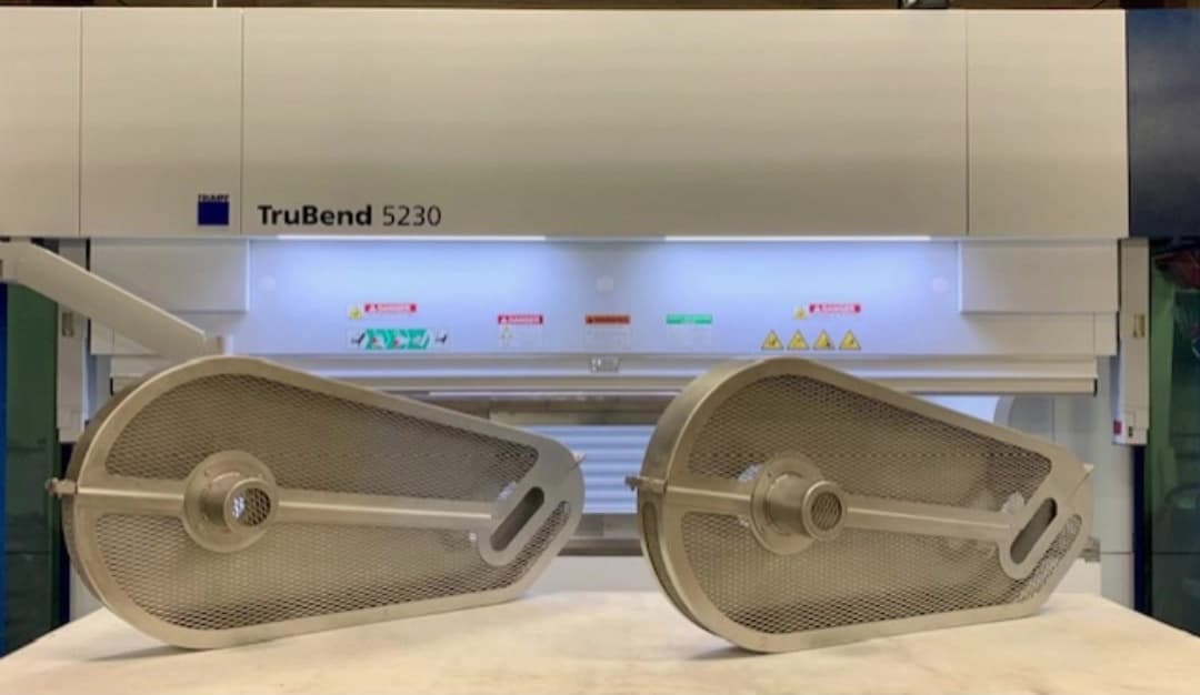 Two custom metal mesh filter screens with oval frames displayed in front of the Trumpf TruBend 5230 press brake